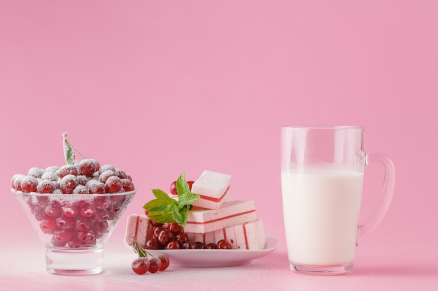 Glass of milk and wild cherry with sugar powder