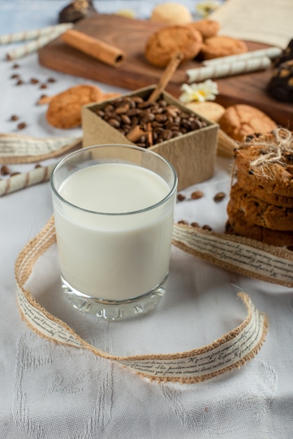 A glass of milk with cookies around