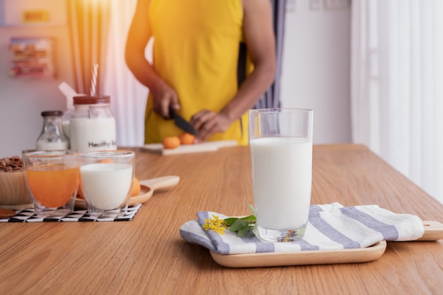 Glass of milk with human preparing food for healthy and breakfast table. 