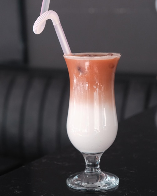 Photo a glass of milk with a straw in it and a straw in it