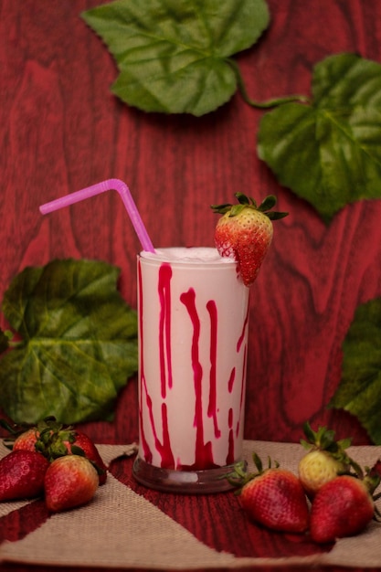 Photo a glass of milk with a strawberry on it