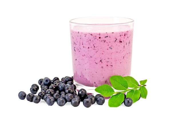 The glass of milkshake, berries and green sprig of blueberries isolated 