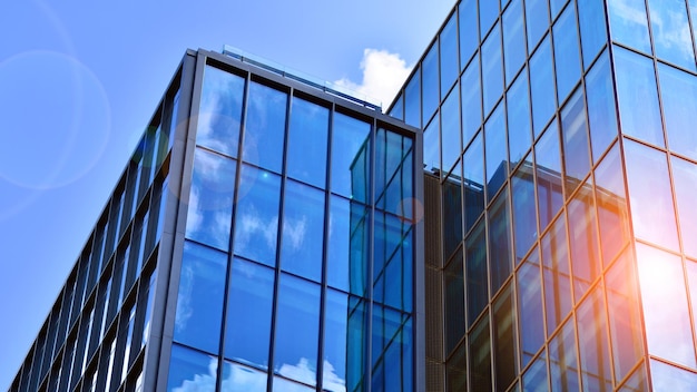 青い空を背景にガラス張りのモダンな建物ビューと建築の詳細都市の抽象