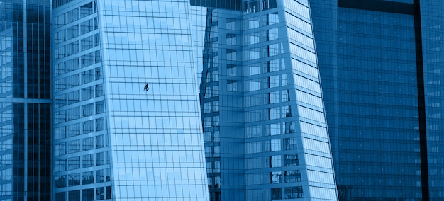 Glass modern office buildings with window washer, panoramic horizontal background