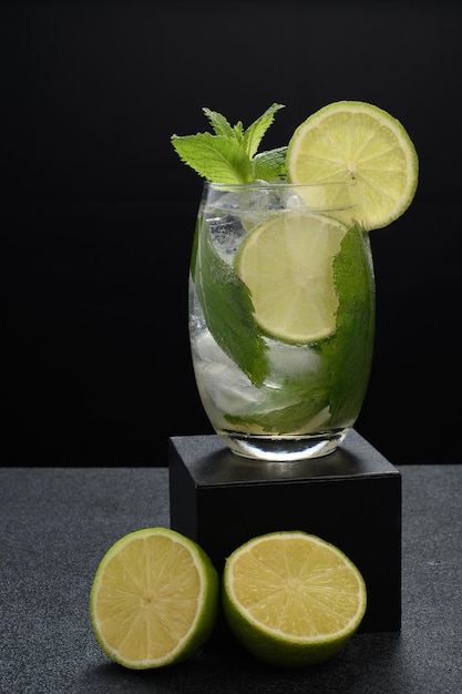 a glass of mojito cocktail on a dark background