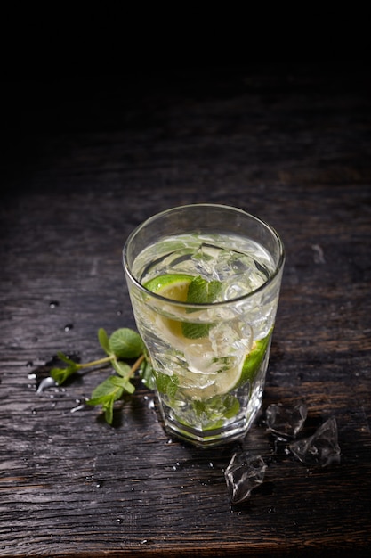 Glass of mojito with lime and mint ice cubes