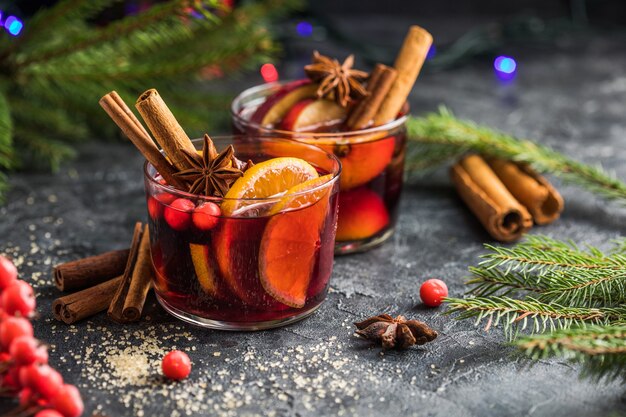 Glass mugs of mulled wine with spices and citrus fruits. Traditional hot drink or beverage, festive cocktail at X-mas or New Year