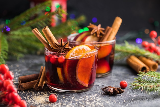 スパイスと柑橘系の果物を混ぜたグリューワインのガラスのマグカップ。伝統的な温かい飲み物や飲み物、クリスマスや新年のお祝いカクテル