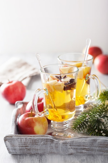 Glass of mulled apple cider with orange and spices, winter drink