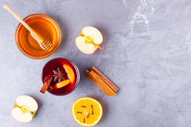 Glass of mulled wine with spices on gray background Christmas mulled wine with orange