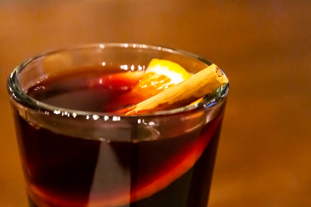 Glass of mulled wine on a wooden table closeup selective focus