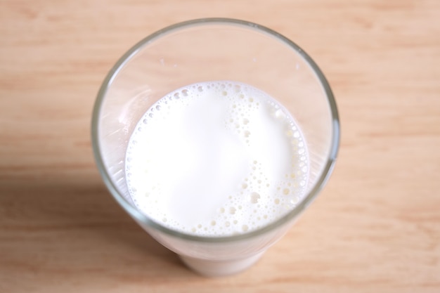 Glass of natural fresh milk on wooden background 