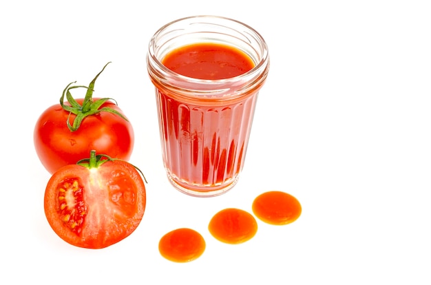 Glass of natural tomato juice on white surface