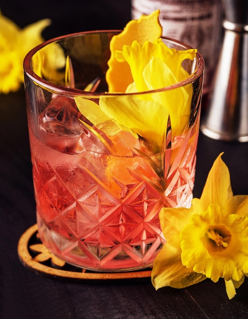 Glass of negroni cocktail decorated with flowers