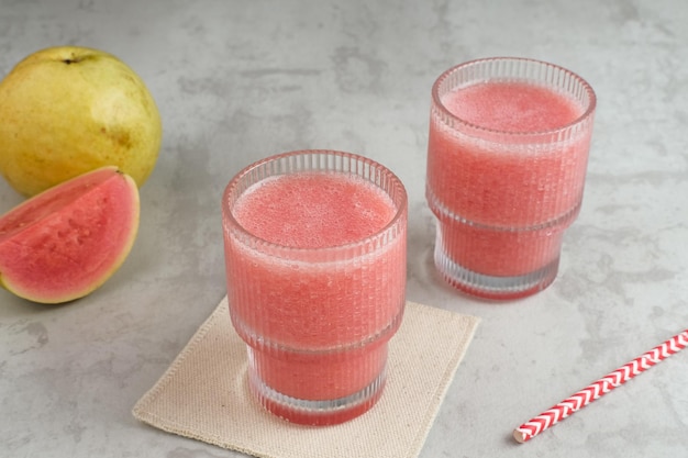 Un bicchiere di nutriente succo di guava rosa biologico.