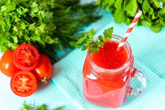 木製のテーブルの上の赤いトマトジュースのガラス