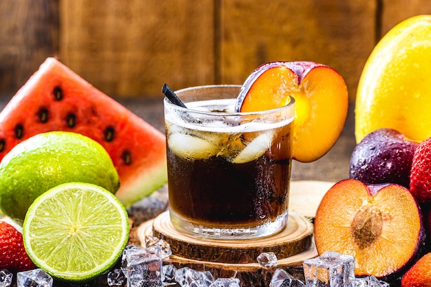 写真 カイピリーニャと呼ばれる典型的なブラジルの飲み物のグラス、プラムフレーバー、フルーツ、蒸留アルコール、砂糖で作られています。