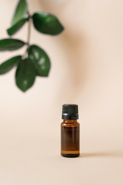 Glass oil bottle and tropical plants leaves