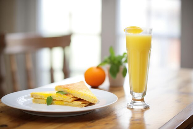 朝食のクレープの隣にオレンジジュースグラス