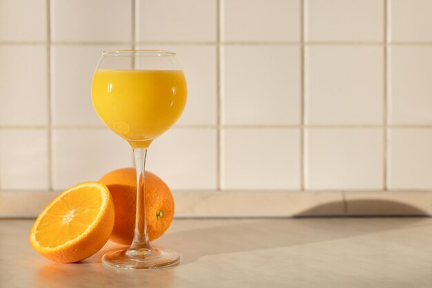 A glass of orange juice in the morning light on the countertop in the kitchen