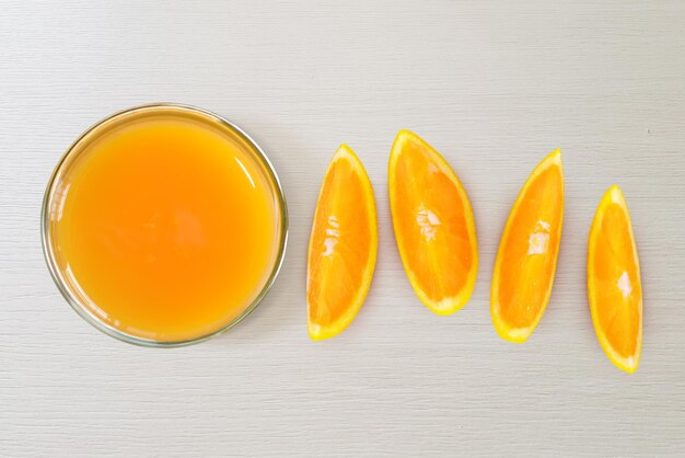 A glass of orange juice and sliced oranges top view isolated on white background