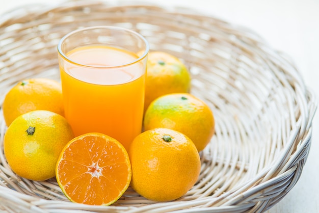 Glass of orange juice a wicker basket