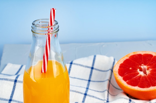 Glass of orange juice with red straw on table