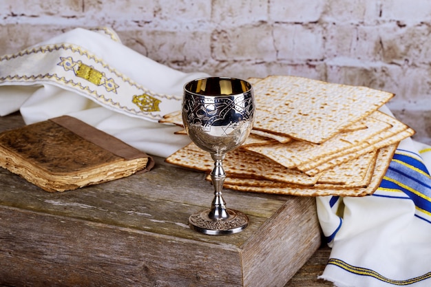 Glass of Passover wine and matzah closeup. Backlit blurred matzah texture in background.
