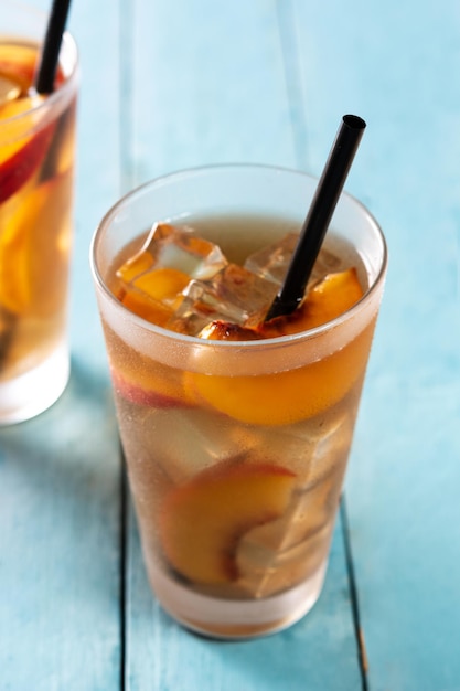 Glass of peach tea with ice cubes