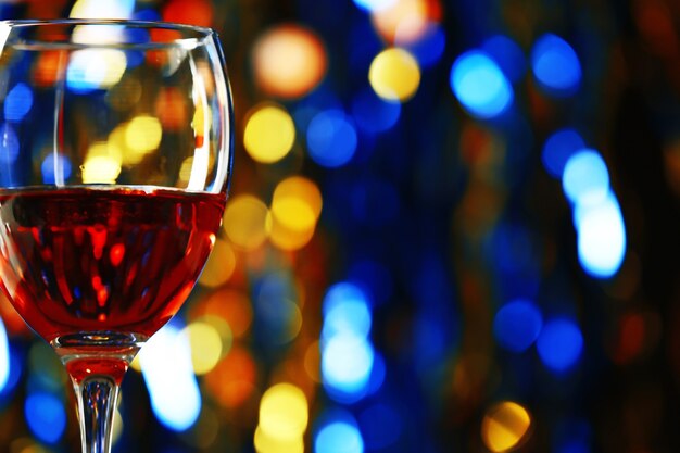 A glass of pink wine on blurred lighted surface