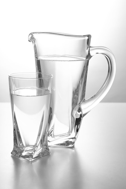 Glass pitcher and glass of water isolated on white