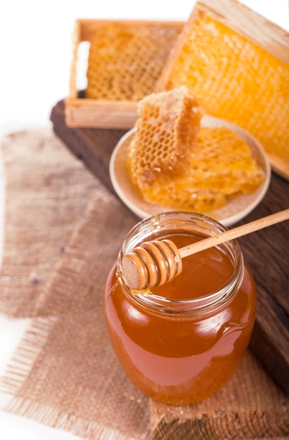 Glass pot with floral honey isolated on white background.