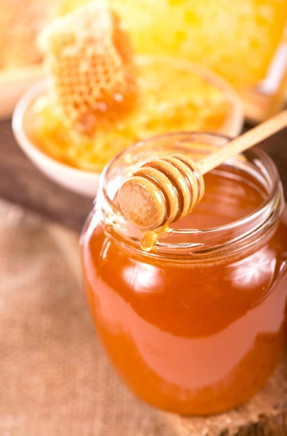 Glass pot with floral honey isolated on white background.