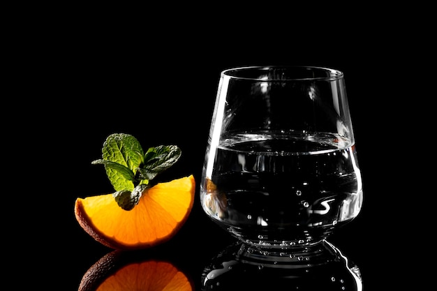 Un bicchiere di acqua pura e una fetta di arancia alla menta