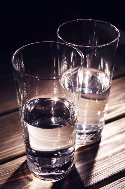 Glass of pure water on wooden background