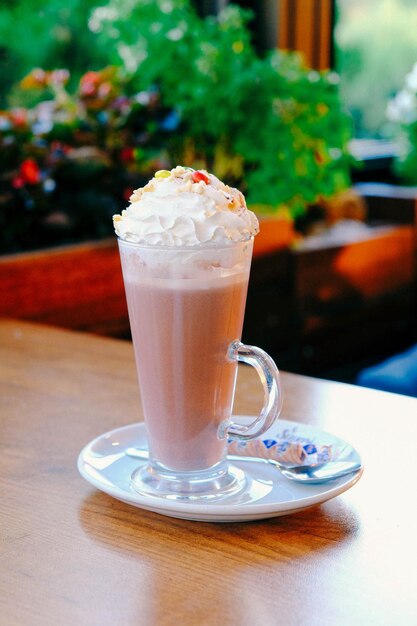 Glass of raspberry milkshake with whipped cream and fresh raspberries