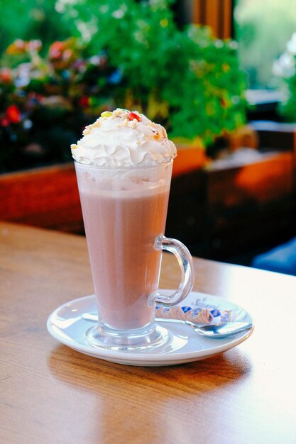 Glass of raspberry milkshake with whipped cream and fresh raspberries