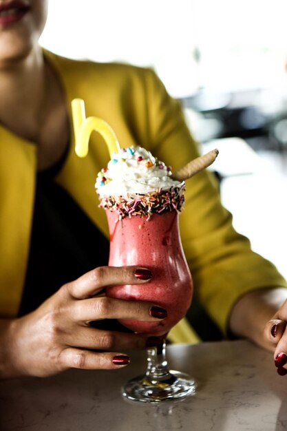 Glass of raspberry milkshake with whipped cream and fresh raspberries