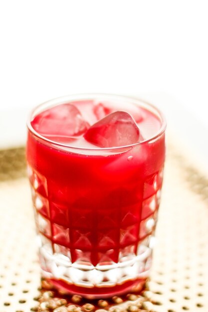 Glass of red cocktail with ice luxury bar party