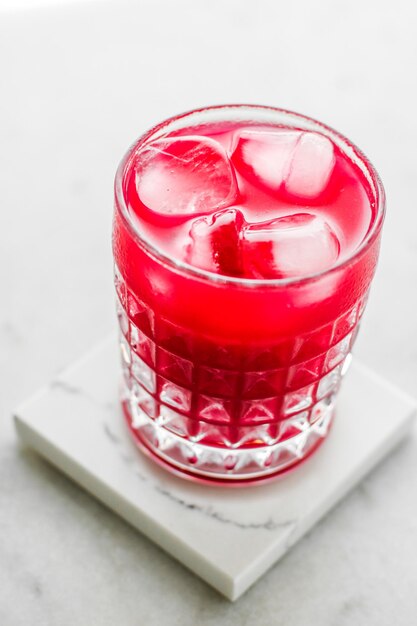 Glass of red cocktail with ice luxury bar party