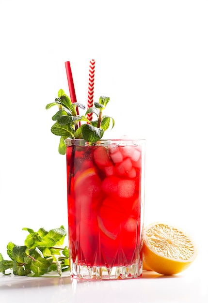 Glass of red tea with ice, mint and lemon on a white background