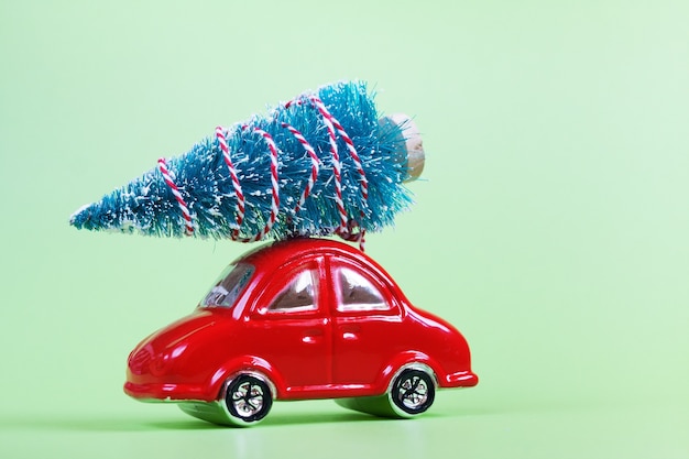 Glass red toy car with christmas decoration on green