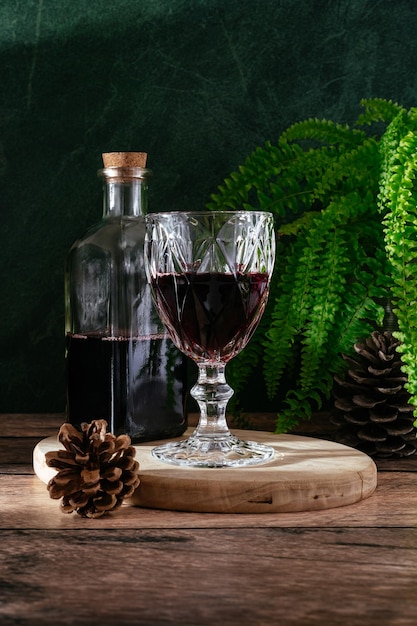 暗い森の背景に赤ワインのグラス