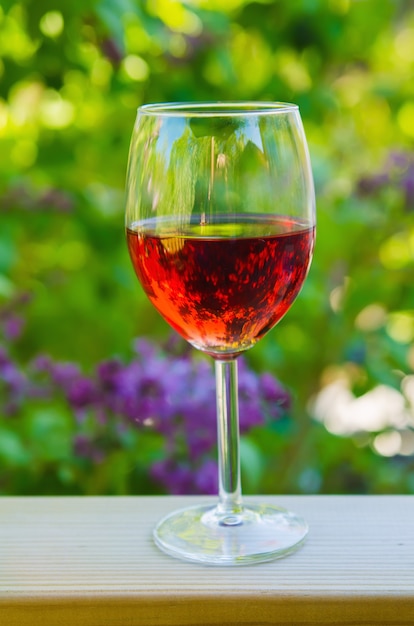 Glass of red wine in the garden, natural drink organic background