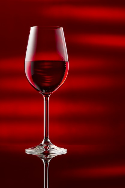 光沢のあるテーブルの上に赤ワインのグラス。