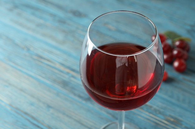 Glass of red wine and grape on wooden table