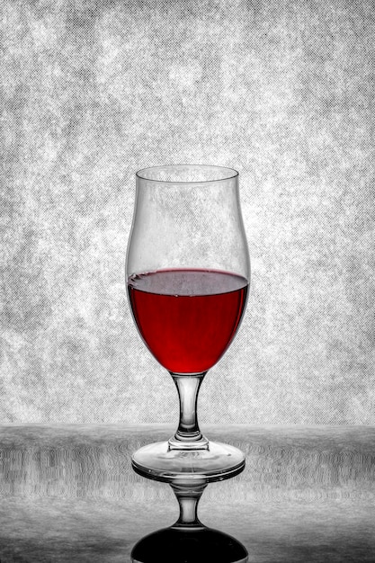 Foto un bicchiere di vino rosso su uno sfondo grigio