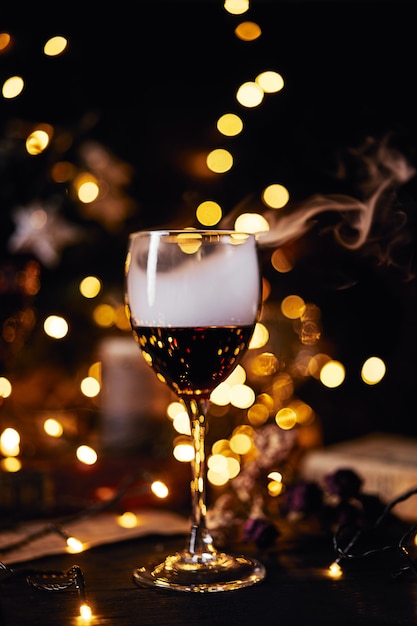 Glass of red wine. Smoke clubs. bokeh background. Christmas, New Year's or Saint Valentine holiday.