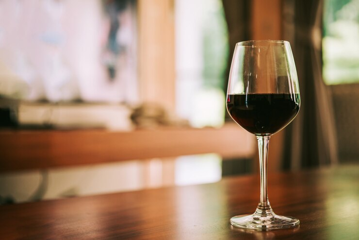Glass of red wine on table in house