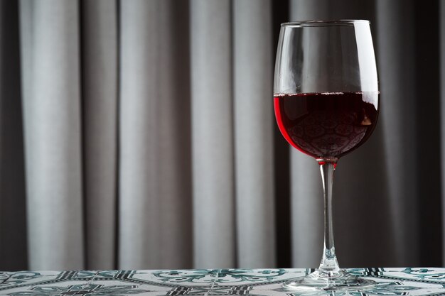タイルテーブルのクローズアップに赤ワインのガラス